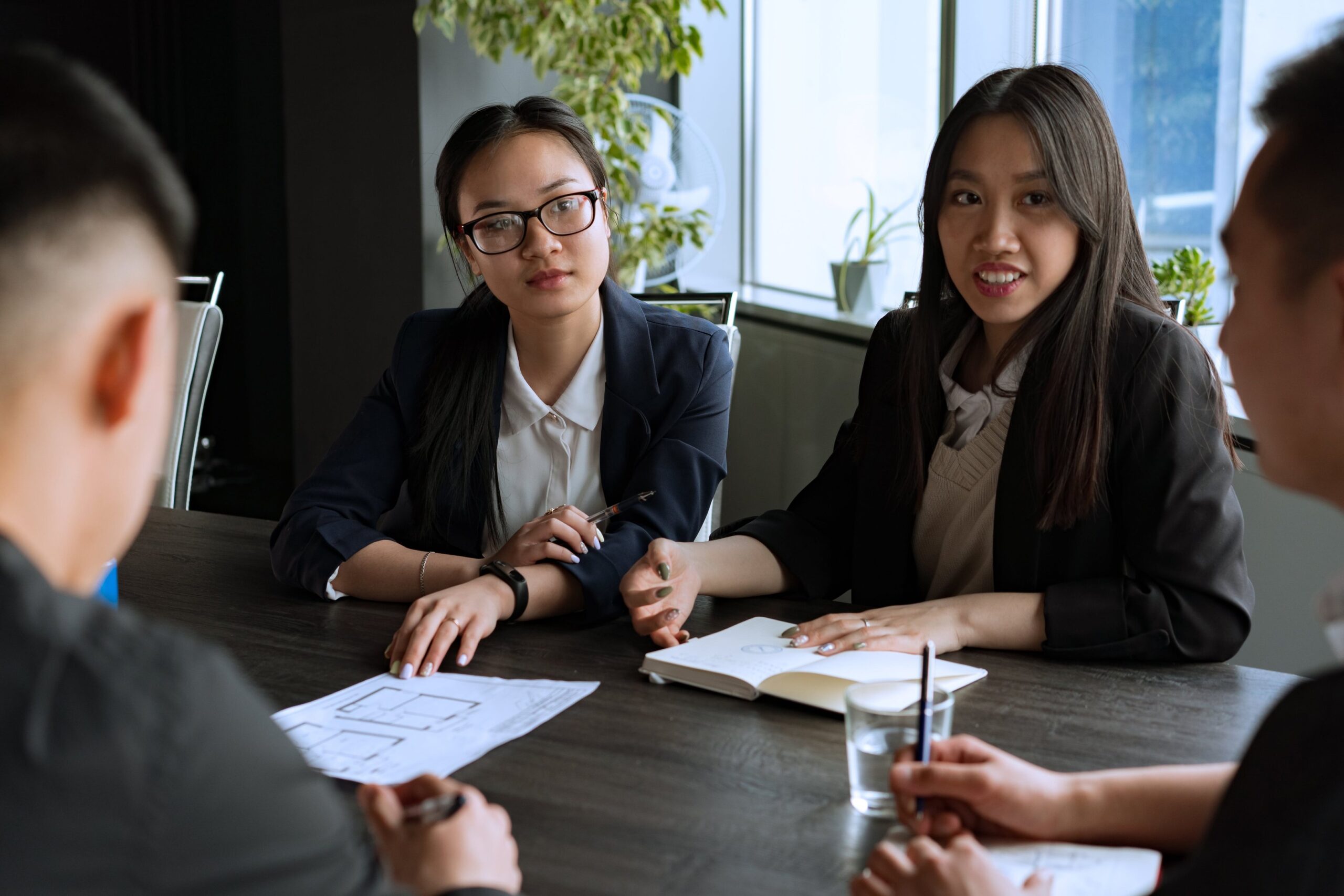 Two women in a meeting with others.